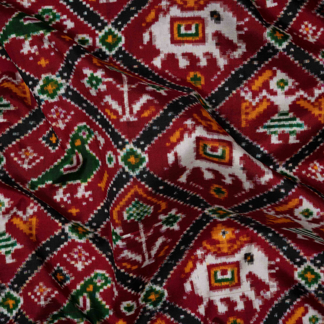 Close-up of a fabric with elephant and diamond pattern on a red background