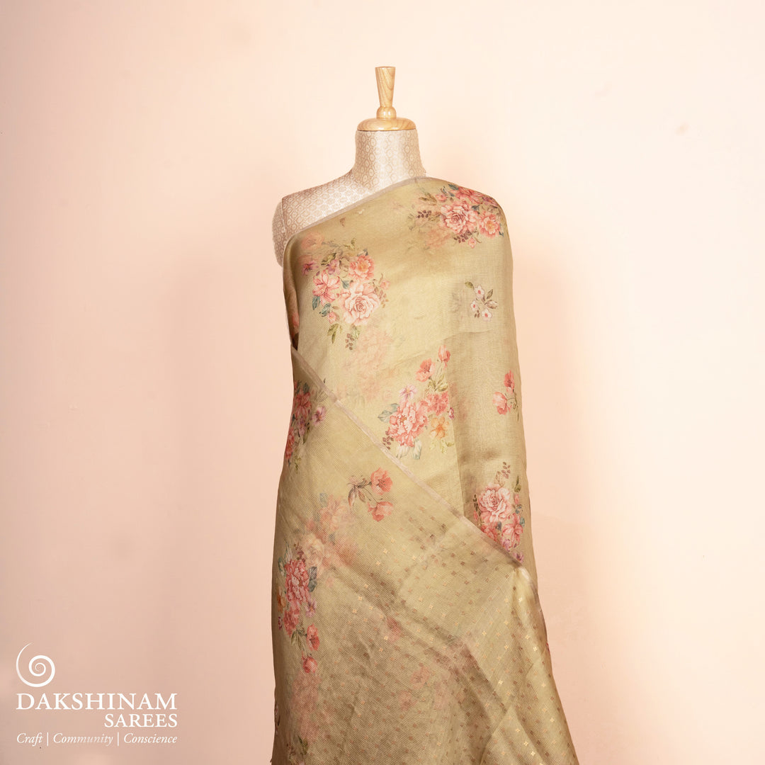 Floral saree on a mannequin with a soft pink background, featuring the brand 'Dakshinam'.