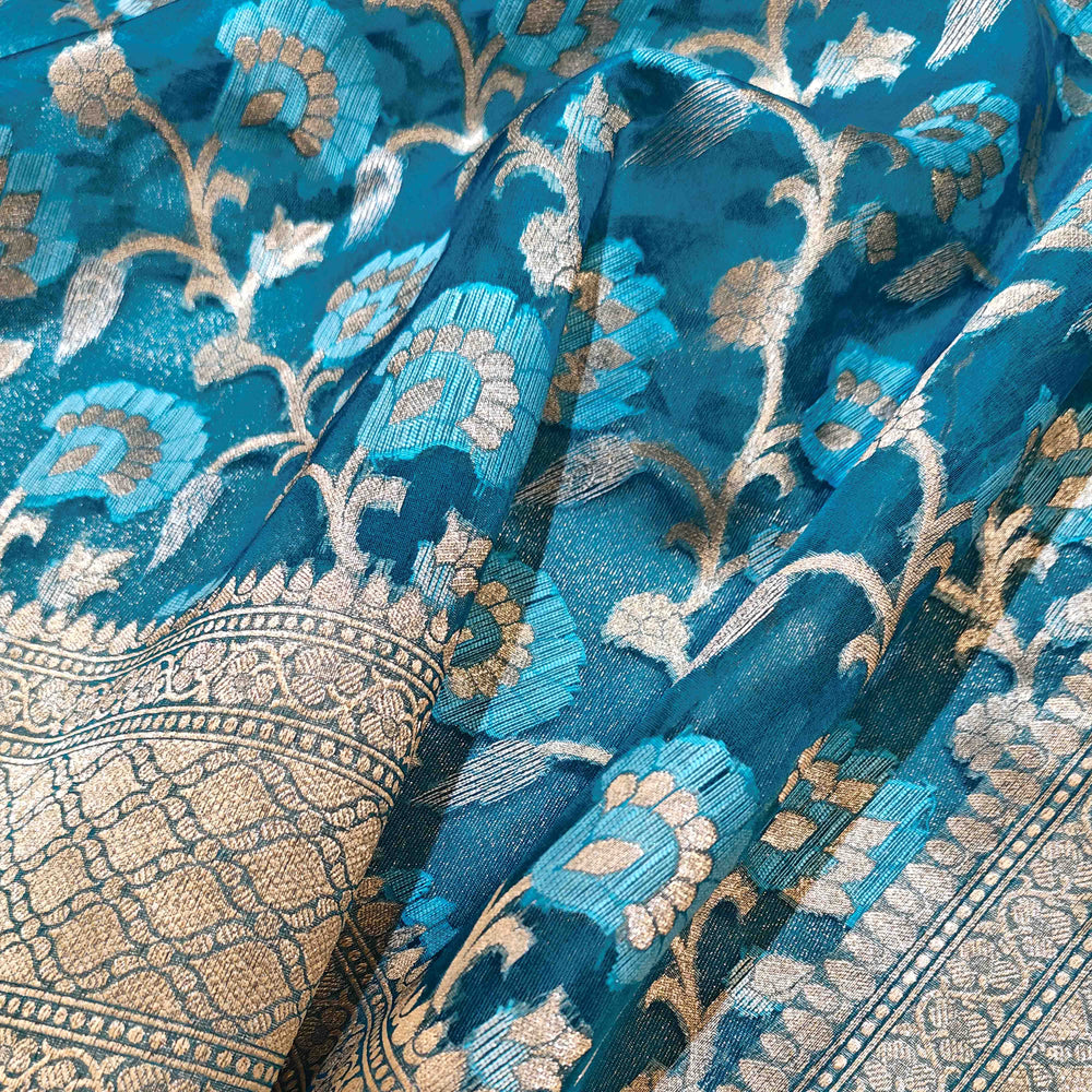 Close-up of blue fabric with intricate gold patterns