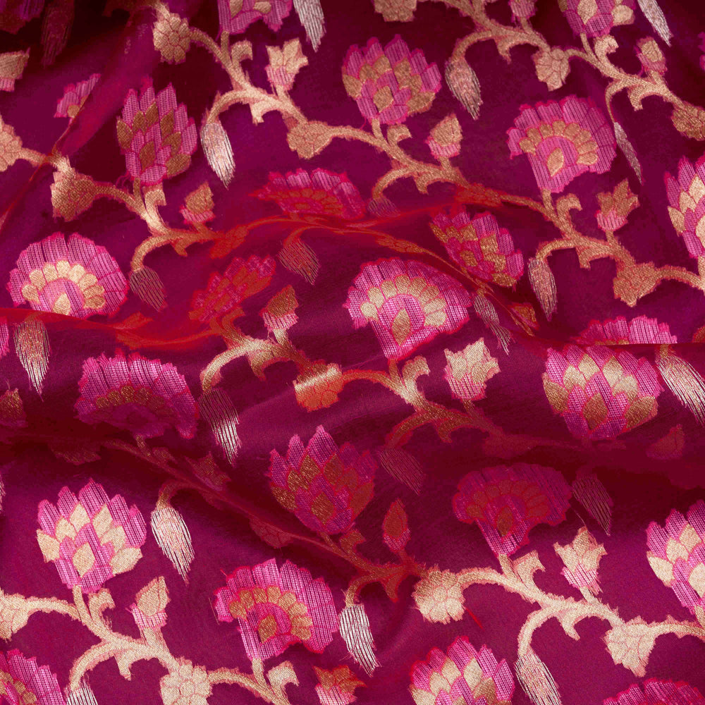 Close-up of pink fabric with intricate floral embroidery on a pink background