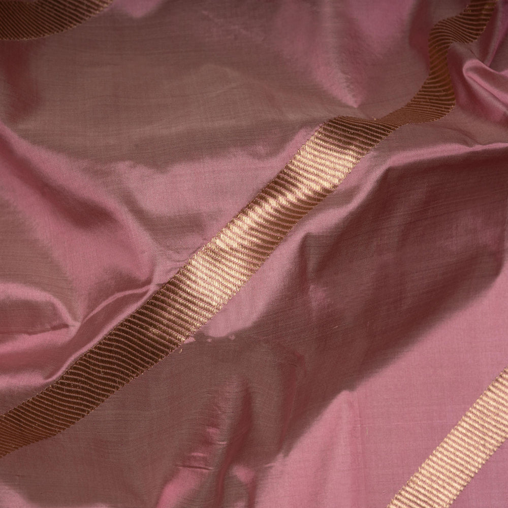 Close-up of pink fabric with a gold ribbon