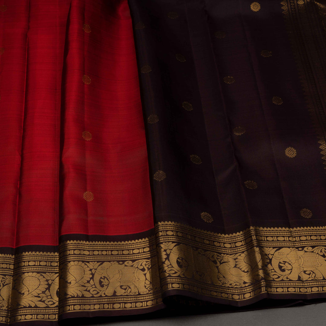 Red and black saree with gold patterns on a gray background