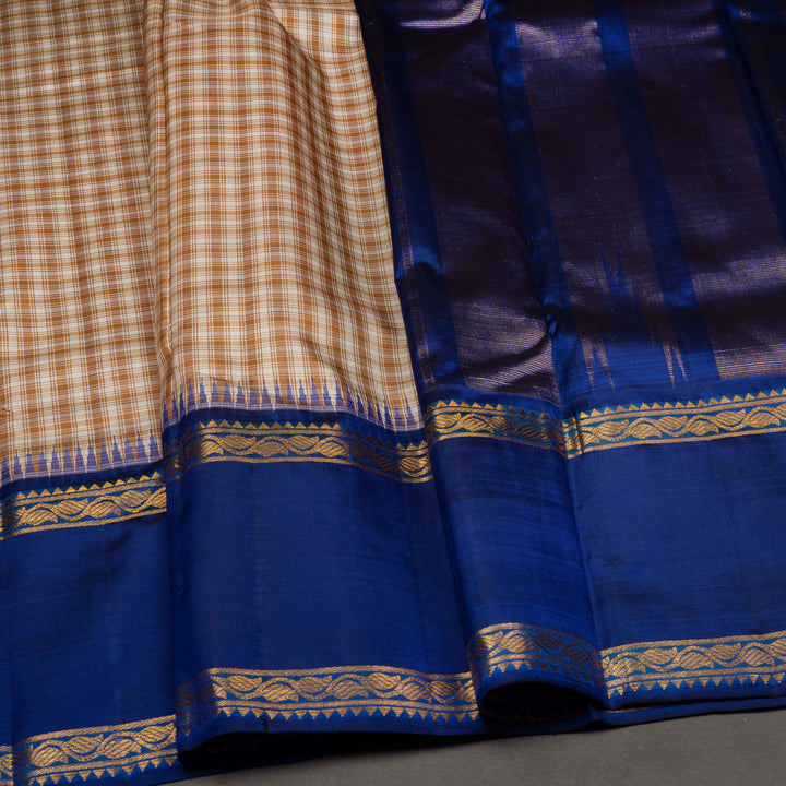Close-up of a blue fabric with gold patterns and a checkered pattern on a gray background