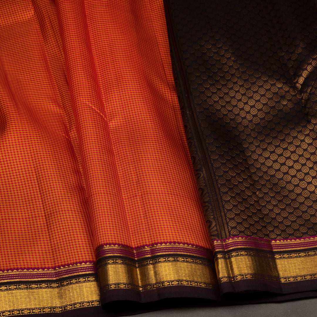 Close-up of a red and black saree with gold border