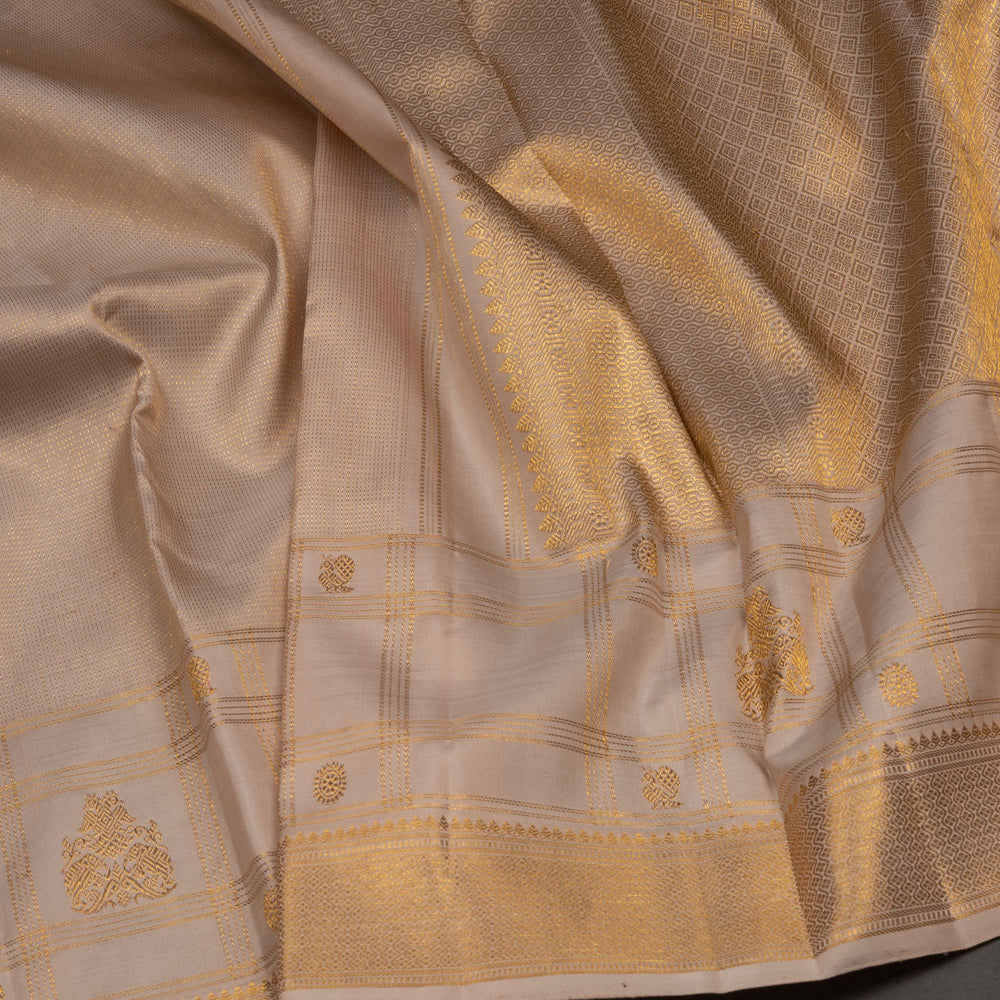 Close-up of a beige fabric with gold embroidery and patterns