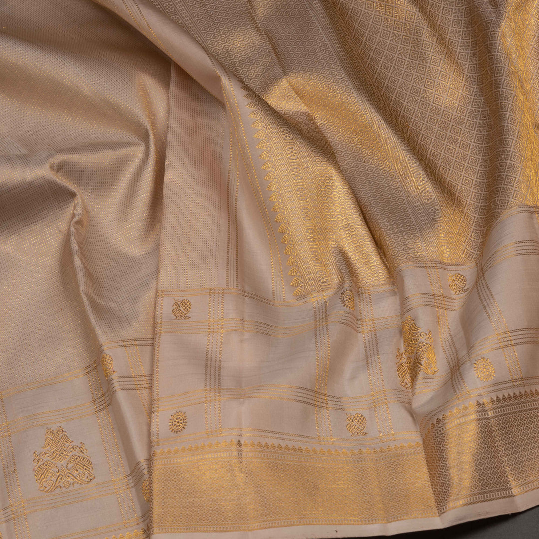 Close-up of a beige fabric with gold embroidery and patterns
