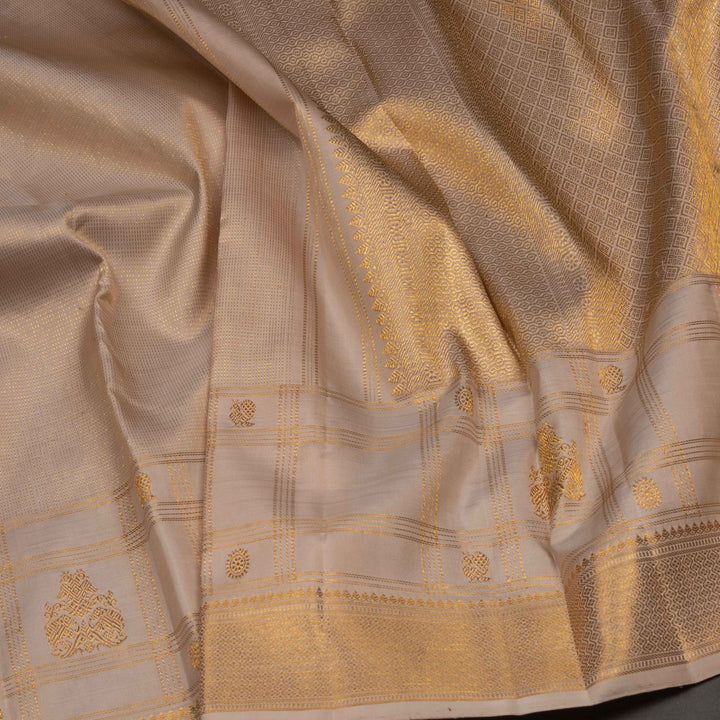 Close-up of a beige fabric with gold embroidery and patterns