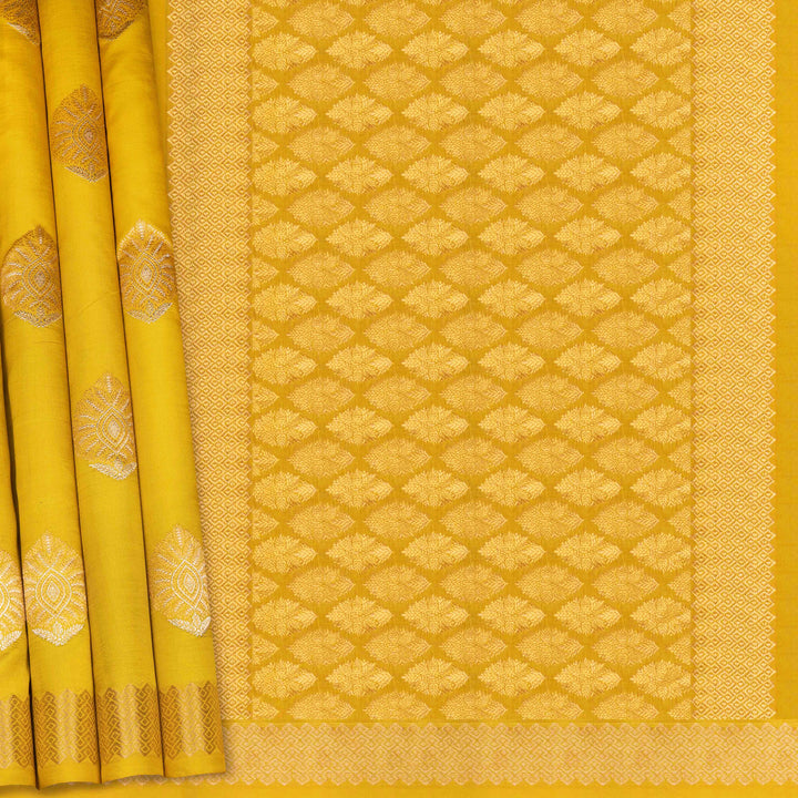 Yellow saree with intricate patterns on a plain background