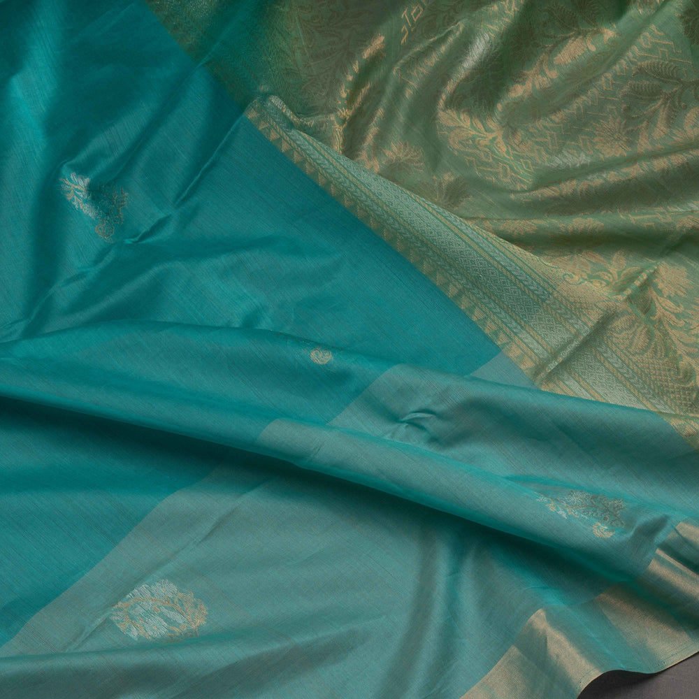 Close-up of a turquoise fabric with intricate gold patterns