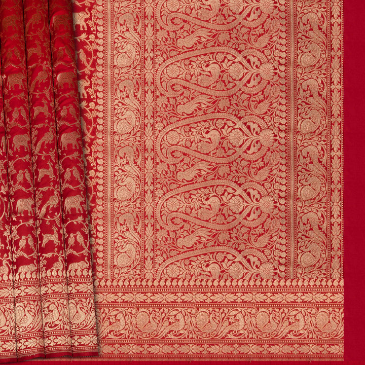 Red fabric with intricate gold patterns and elephant designs