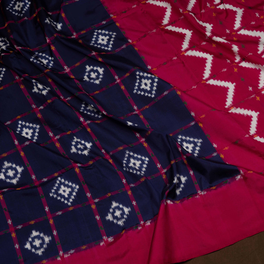 Close-up of patterned fabric with blue and white geometric design on a red background