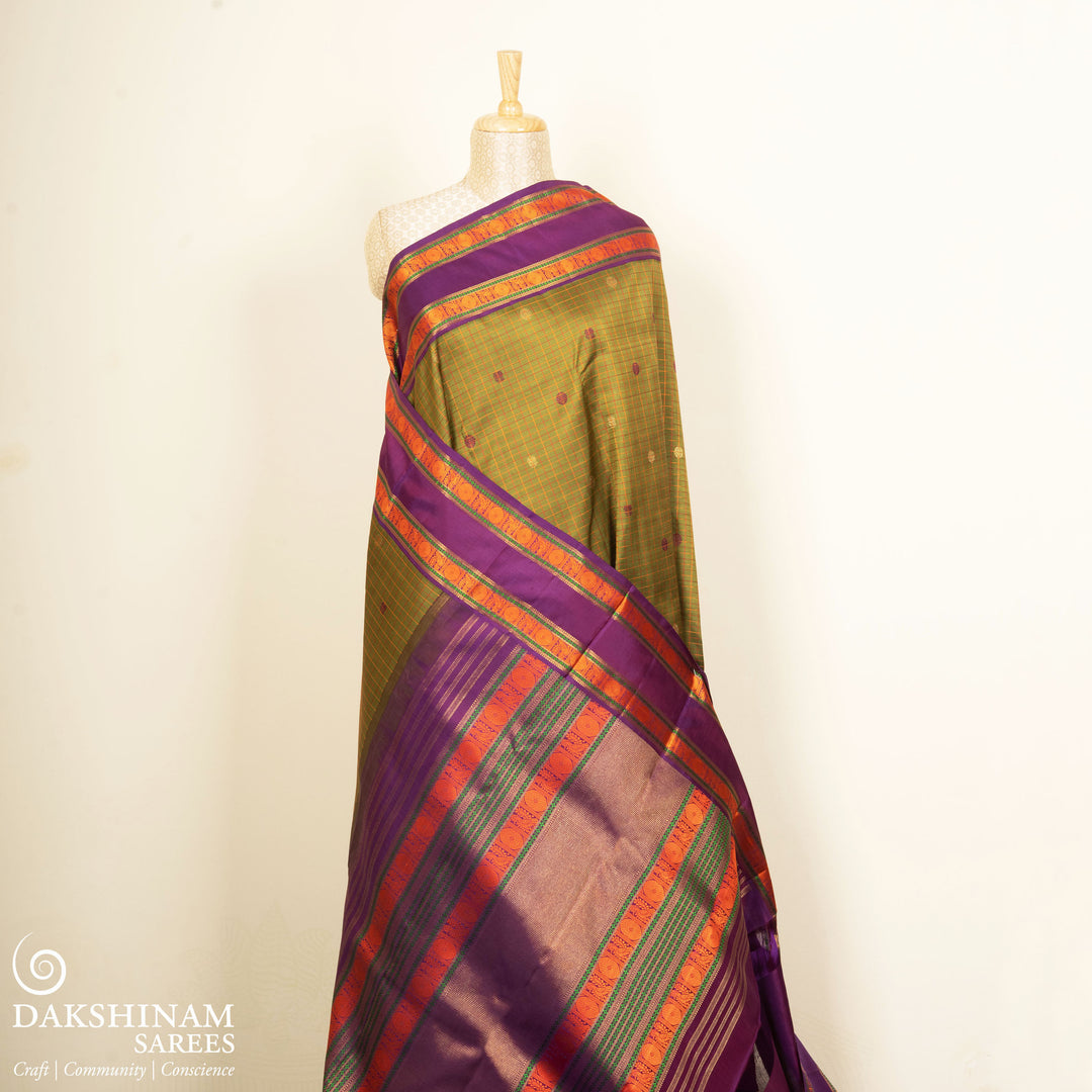 Olive green Kanjivaram silk saree with checks, annam and chakram butta, violet rettapet border and matching blouse