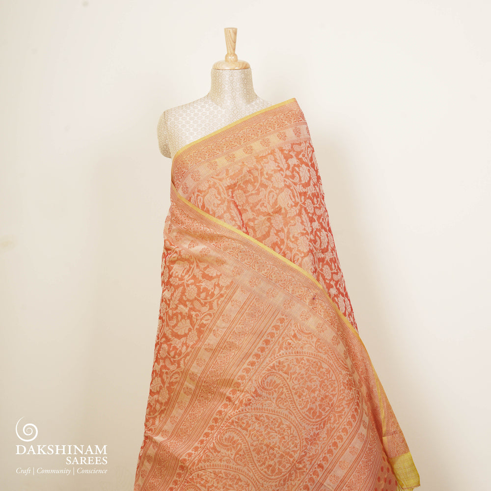 Orange South cotton saree with floral body featuring peacock, horse, elephant, deer and tiger motifs, traditional border and paisley pallu, matching blouse with dot design.