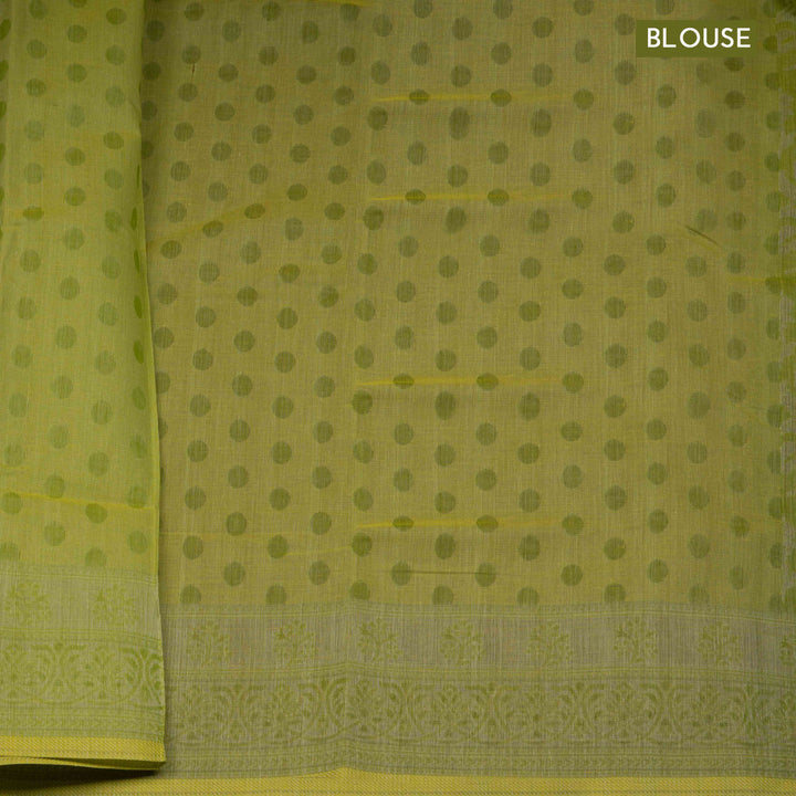 Lime green South cotton saree with floral body featuring peacock, horse, elephant, deer and tiger motifs, traditional border and paisley pallu, matching blouse with dot design.