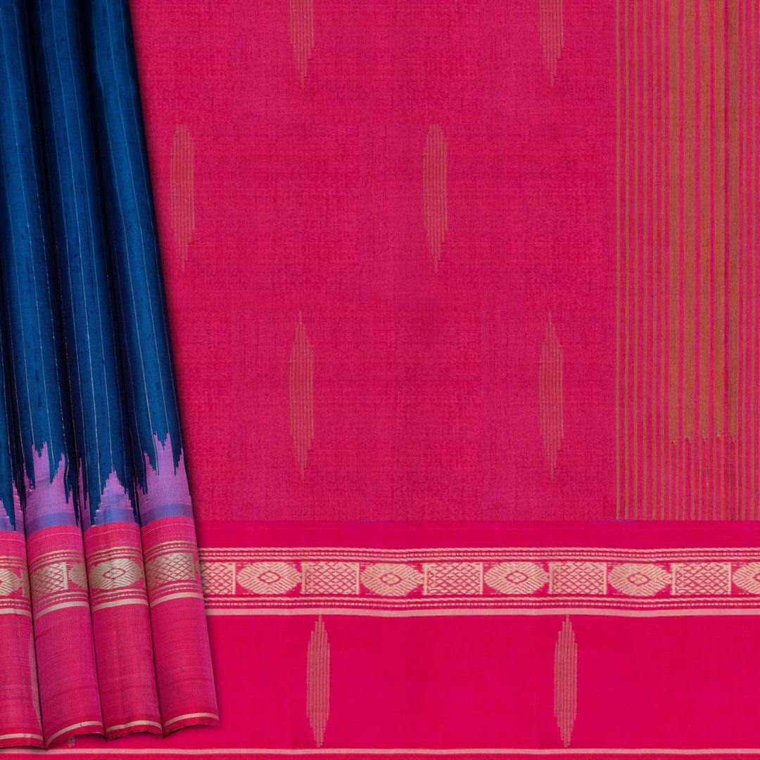 Blue Gadwal silk saree with raw silk finish body, silver stripe detailing, pink border with chakram and thazampoo motifs, pink blouse.