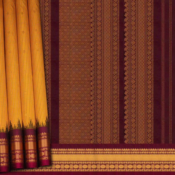 Yellow Gadwal silk saree with maroon checks and small butta body, maroon zari border with chakram and temple motifs, plain maroon blouse.
