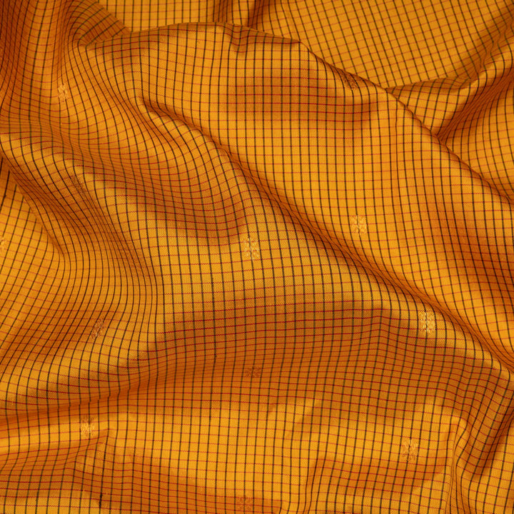 Yellow Gadwal silk saree with maroon checks and small butta body, maroon zari border with chakram and temple motifs, plain maroon blouse.