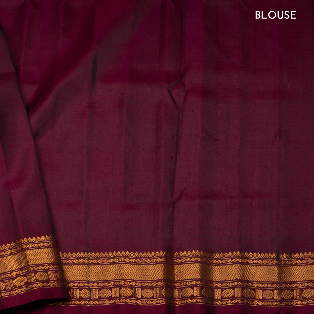 Yellow Gadwal silk saree with maroon checks and small butta body, maroon zari border with chakram and temple motifs, plain maroon blouse.