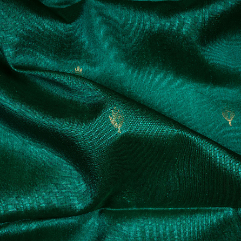 Green Tussar soft silk saree with floral butta body, gold border and pallu with temple design and purple buttas, paired with plain green blouse.