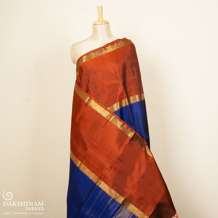 Blue Kanchipuram silk saree with two different gold zari borders featuring diamond and veldhari motifs and zari-lined pallu.