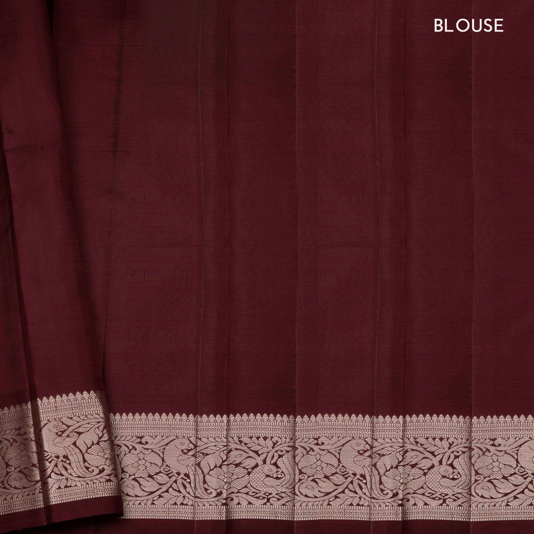 Peach handwoven Kanjivaram silk saree with horizontal stripes and chakram buttas, maroon border with parrot and floral motifs, and matching maroon blouse.