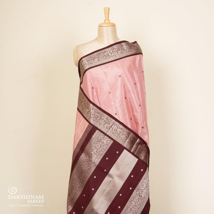 Peach handwoven Kanjivaram silk saree with horizontal stripes and chakram buttas, maroon border with parrot and floral motifs, and matching maroon blouse.