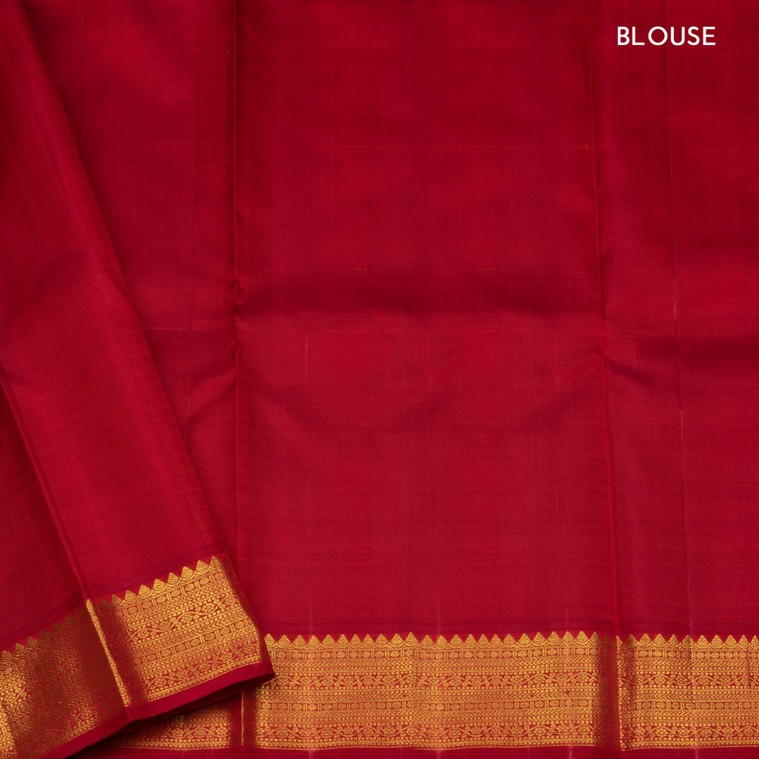 Blue handwoven Kanjivaram silk saree with gold buttas, red border with chevron and floral designs, and matching pallu, paired with plain red blouse.