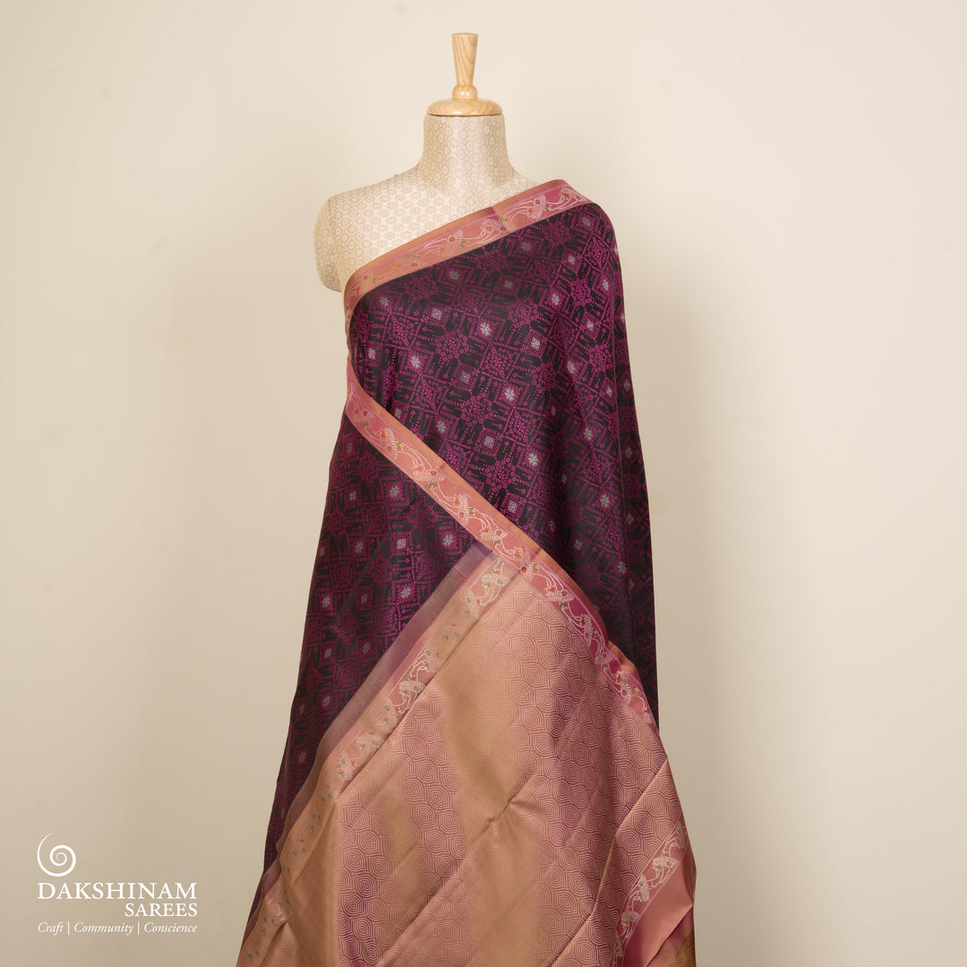 Black handwoven Kanjivaram silk saree with pink thread work, diamond and star zari motifs, peach floral meenakari border, and matching pallu, paired with peach blouse.