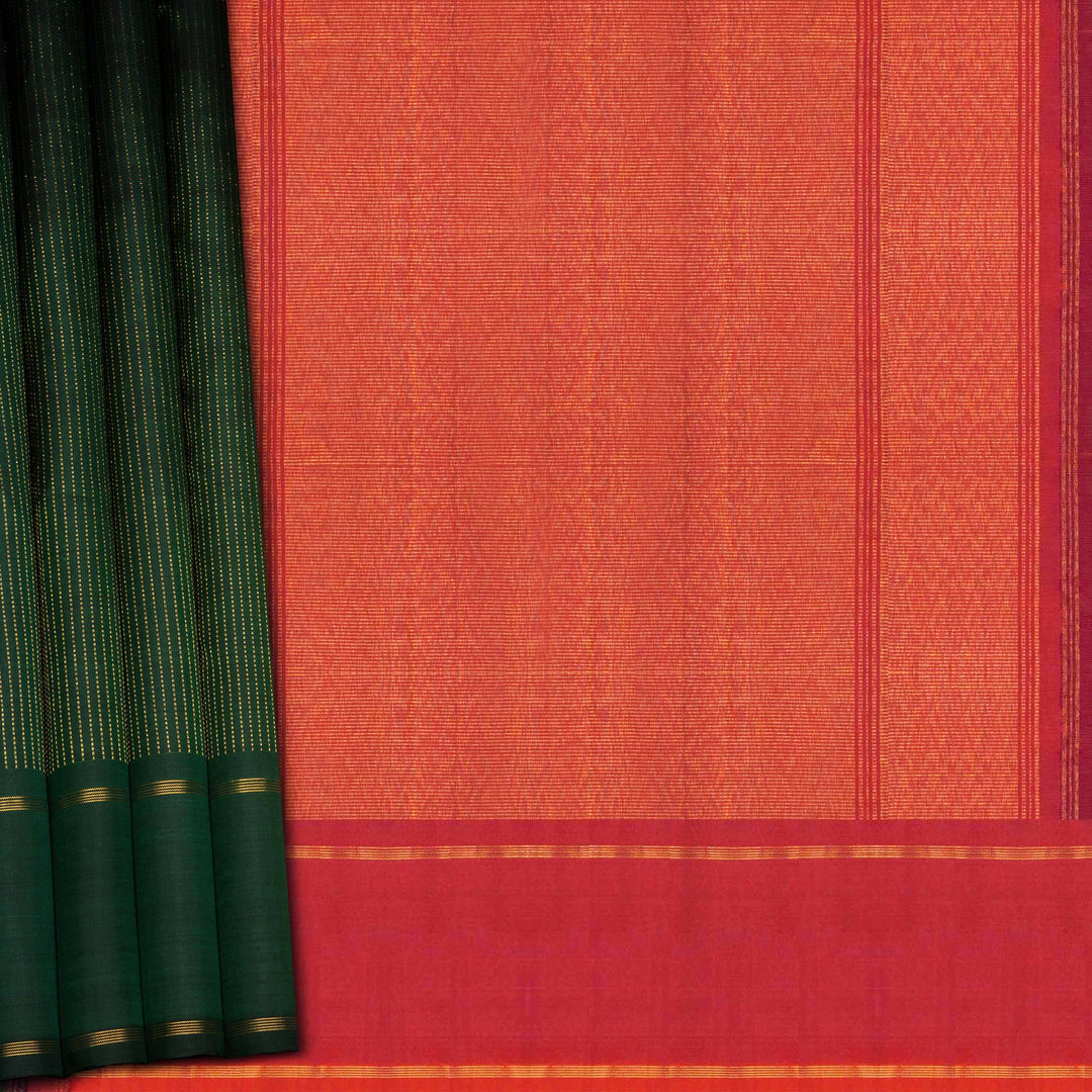 Green handwoven Kanjivaram silk saree with vertical gold dash buttas, rettapet border, and peach-pink dual tone pallu with zari motifs, paired with peach blouse.