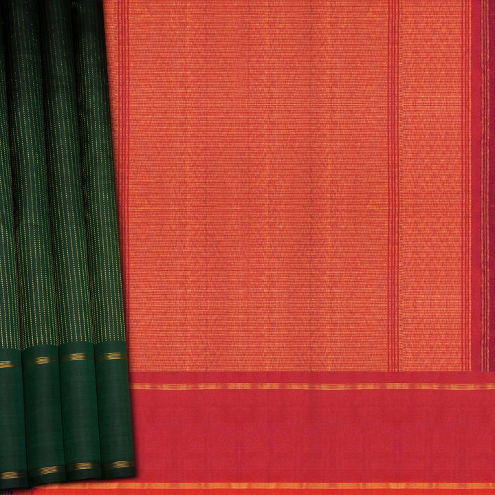 Green handwoven Kanjivaram silk saree with vertical gold dash buttas, rettapet border, and peach-pink dual tone pallu with zari motifs, paired with peach blouse.
