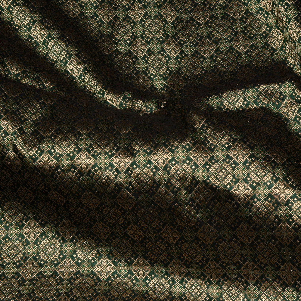 Dark green Banarasi silk saree with all-over gold brocade featuring round and diamond buttas, intricate zari border with chevron and traditional motifs, paired with a plain dark green blouse.