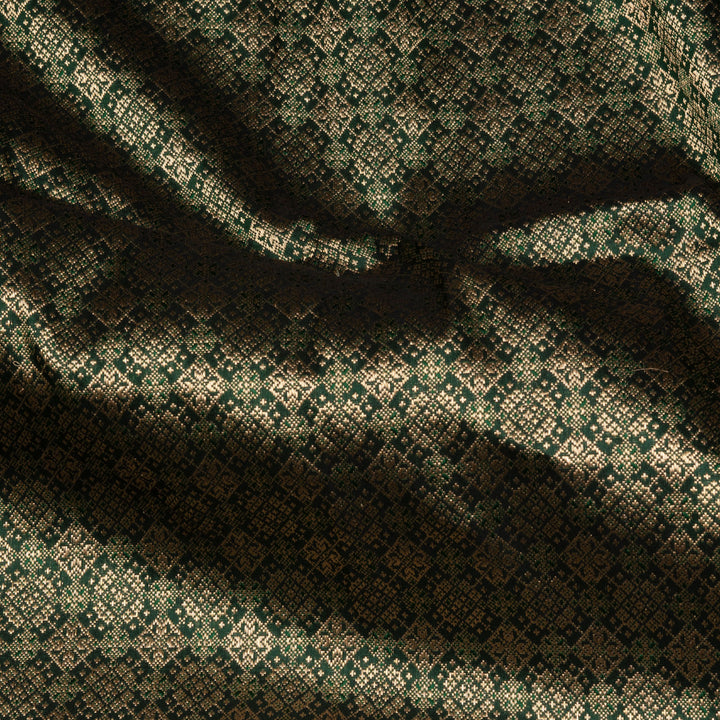 Dark green Banarasi silk saree with all-over gold brocade featuring round and diamond buttas, intricate zari border with chevron and traditional motifs, paired with a plain dark green blouse.