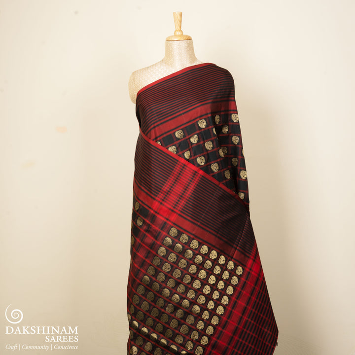 Black Pochampally Ikat silk saree with ikat checks, kadiyal butta, black border with red panel and rectangular patterns, paired with off-white ikat blouse.