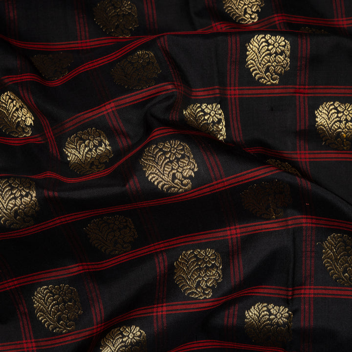 Black Pochampally Ikat silk saree with ikat checks, kadiyal butta, black border with red panel and rectangular patterns, paired with off-white ikat blouse.