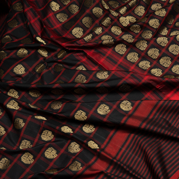 Black Pochampally Ikat silk saree with ikat checks, kadiyal butta, black border with red panel and rectangular patterns, paired with off-white ikat blouse.