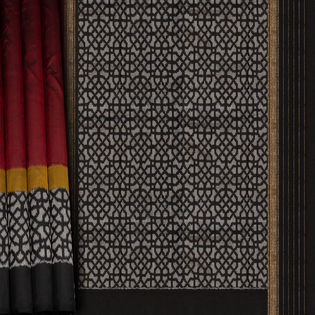 Red Pochampally Ikat silk saree with yellow ikat border, black panel, and black and white ikat pallu, paired with plain black blouse.