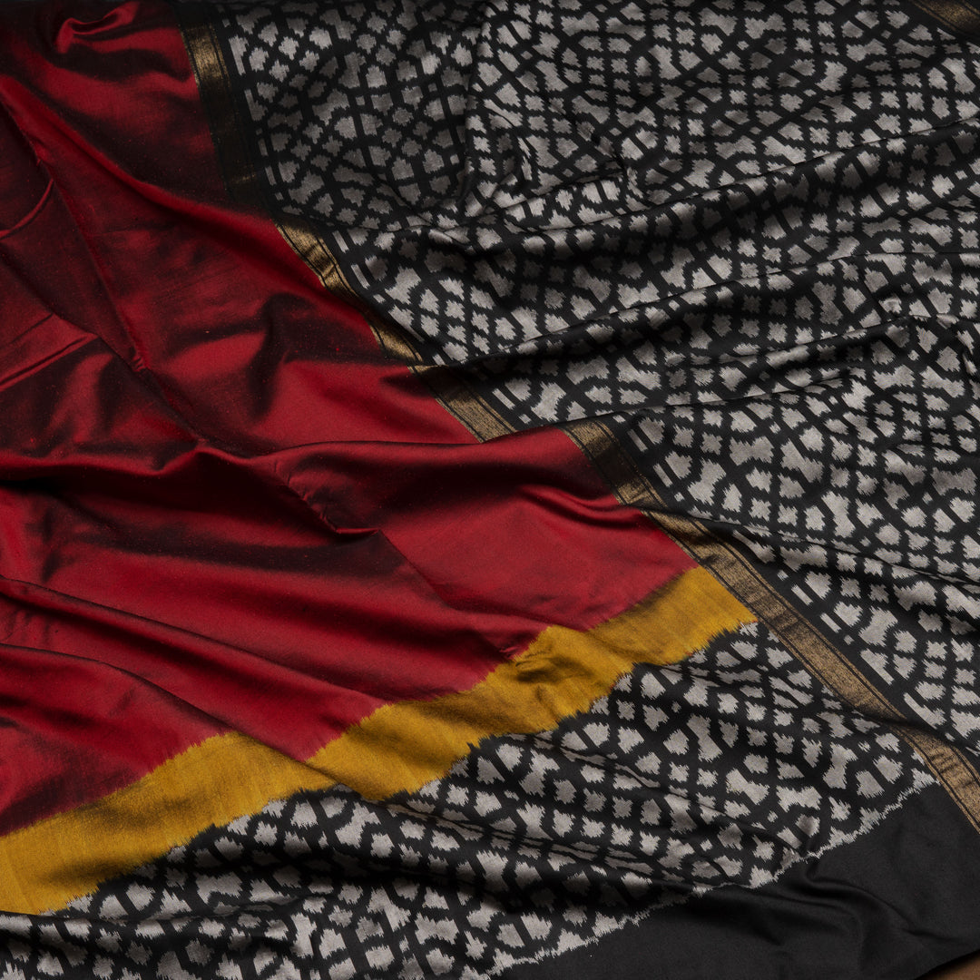 Red Pochampally Ikat silk saree with yellow ikat border, black panel, and black and white ikat pallu, paired with plain black blouse.