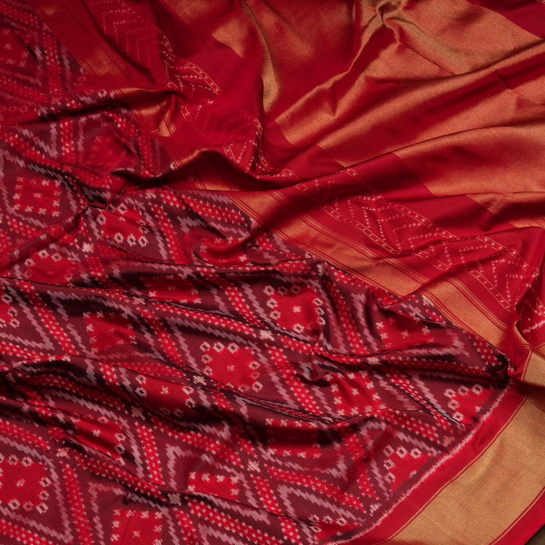 Red Pochampally Ikat silk saree with diamond motifs, red and gold zari border, and temple design pallu with arrow patterns, paired with plain red blouse with zari border.