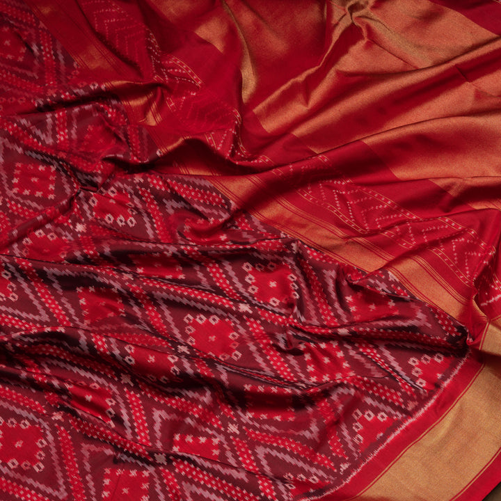 Red Pochampally Ikat silk saree with diamond motifs, red and gold zari border, and temple design pallu with arrow patterns, paired with plain red blouse with zari border.