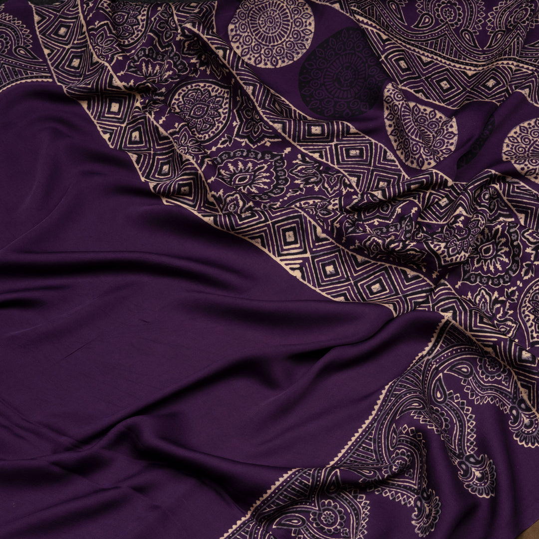 Violet handwoven modal silk saree with plain violet body, Ajrakh printed border, gold zari pallu, paired with a violet Ajrakh design blouse.