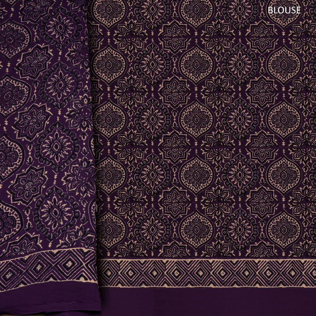 Violet handwoven modal silk saree with plain violet body, Ajrakh printed border, gold zari pallu, paired with a violet Ajrakh design blouse.