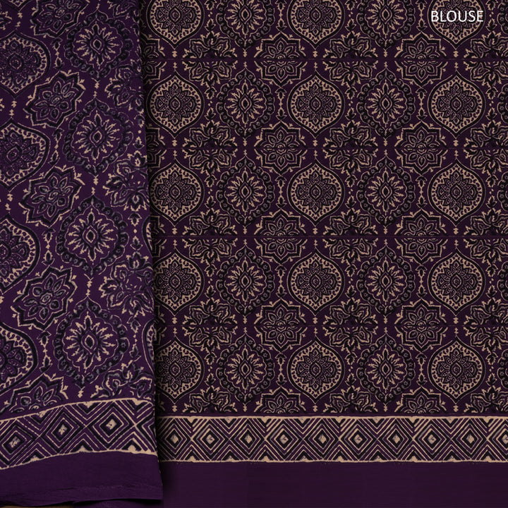 Violet handwoven modal silk saree with plain violet body, Ajrakh printed border, gold zari pallu, paired with a violet Ajrakh design blouse.
