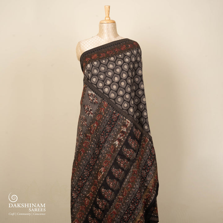 Grey handwoven Chanderi silk saree with Ajrakh print, gicha temple border, floral pallu design, paired with grey blouse with floral vines.