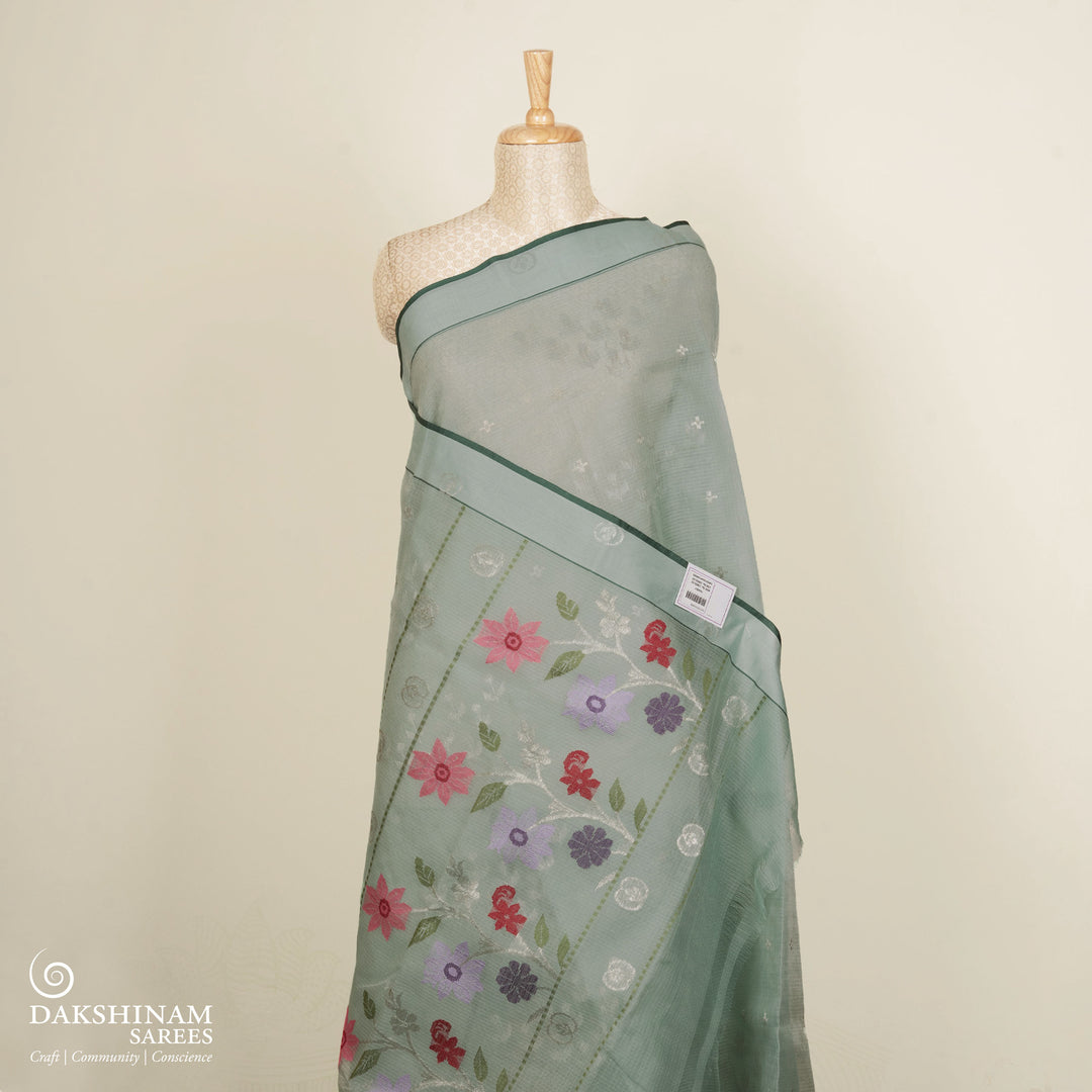 Moss green Kota doria silk saree with silver zari floral motifs, monotone border and pallu with silk thread flowers and chevron blouse