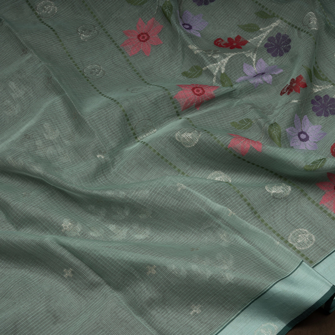 Moss green Kota doria silk saree with silver zari floral motifs, monotone border and pallu with silk thread flowers and chevron blouse