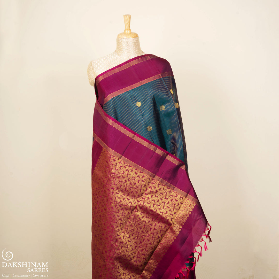 Peacock green Kanjivaram silk saree with gold zari stripes, annam and chakram butta, magenta rettapet border and detailed pallu with matching blouse