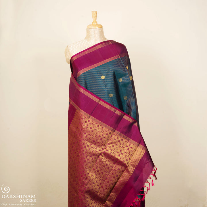 Peacock green Kanjivaram silk saree with gold zari stripes, annam and chakram butta, magenta rettapet border and detailed pallu with matching blouse
