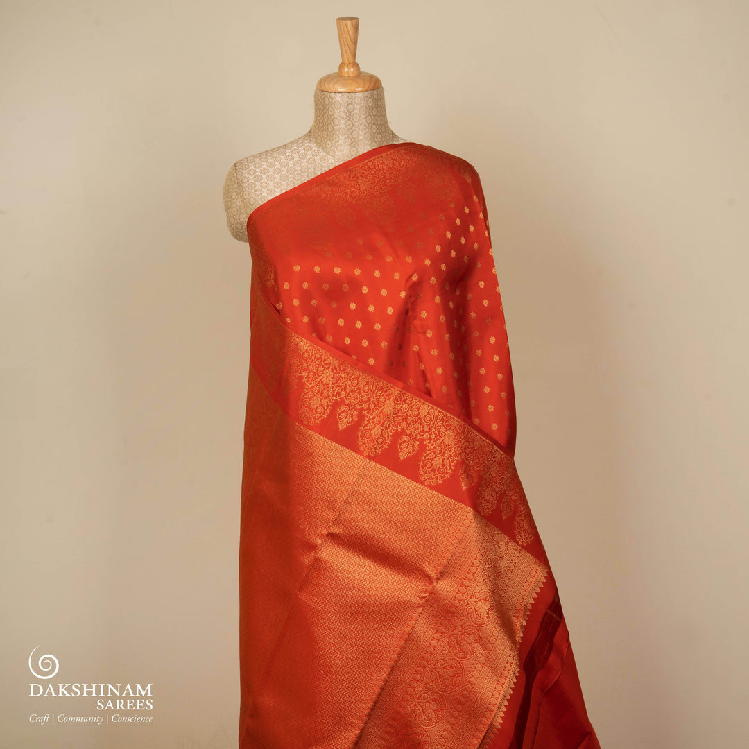 Orange Kanjivaram silk saree with allover diamond butta, turning border and rich pallu with rudraksham, chevron lines and retta killi motifs
