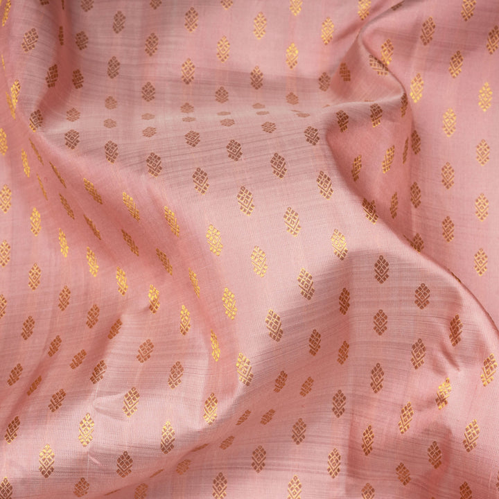 Light peach Kanjivaram silk saree with vairam buttas, peach pink border featuring temple and chevron designs, and detailed zari pallu, paired with plain blouse.
