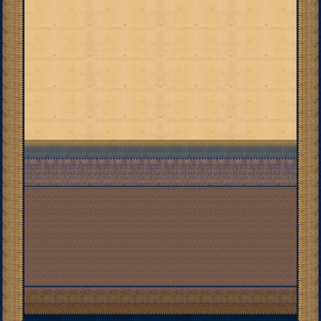 Cream Kanjivaram silk saree with chakram buttas, peacock blue border featuring chevron, rudraksham and floral lines, paired with plain blue blouse.